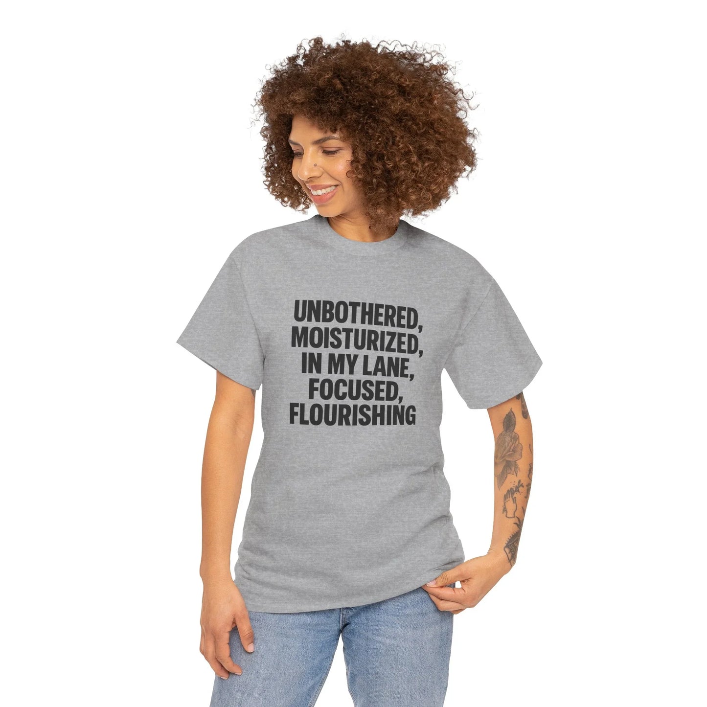 Woman in grey graphic tee with 'Unbothered, Moisturized, In My Lane' text, casual fashion