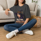 Seated model wearing the Resting Witch Face Halloween graphic tee in black