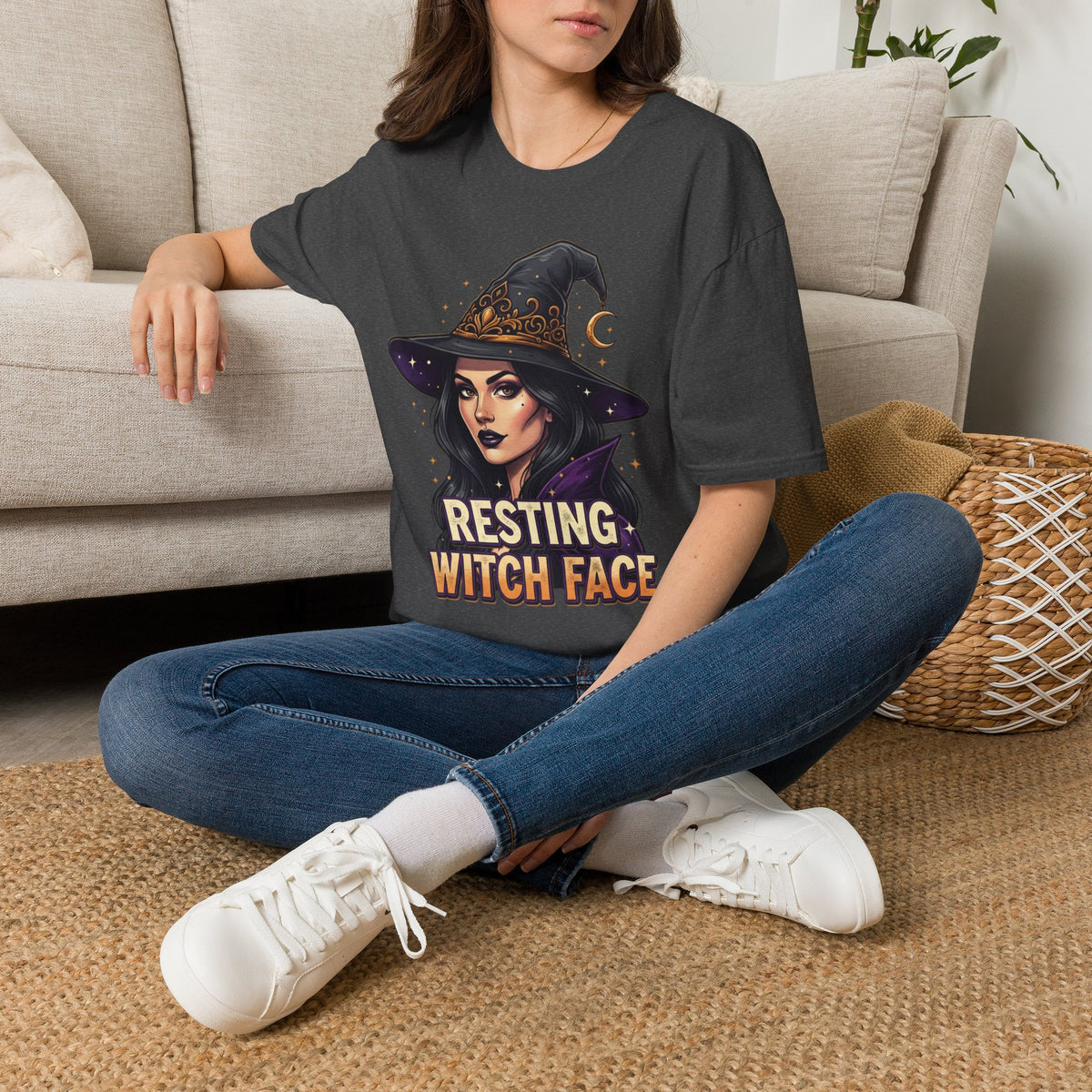 Seated model wearing the Resting Witch Face Halloween graphic tee in black