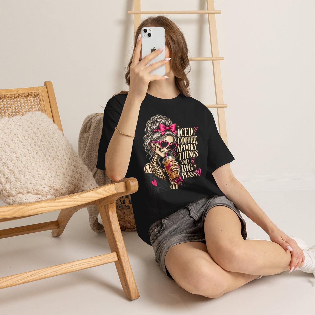 Woman wearing the Iced Coffee & Big Plans black graphic tee in a casual lifestyle setting