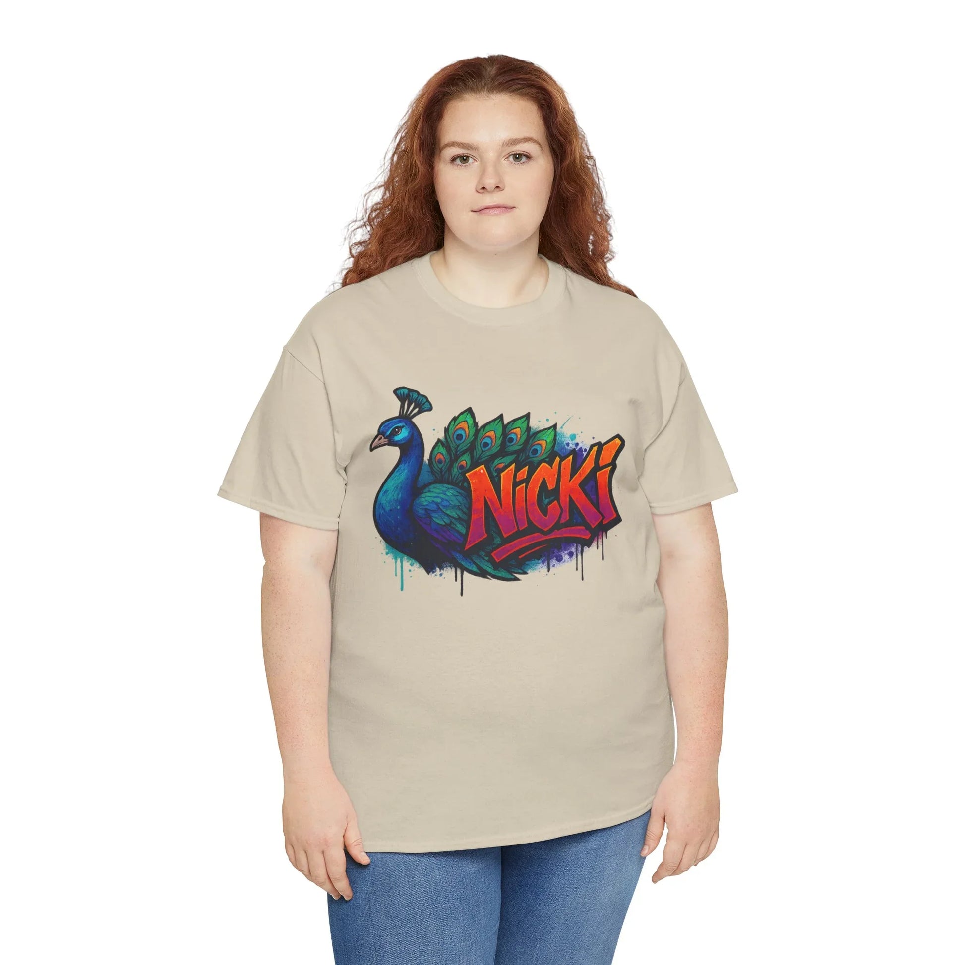 Woman wearing beige t-shirt with colorful peacock and bold 'Nicki' graphic design