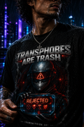 Model wearing the black Transphobes Are Trash trans rights graphic tee in a neon city.