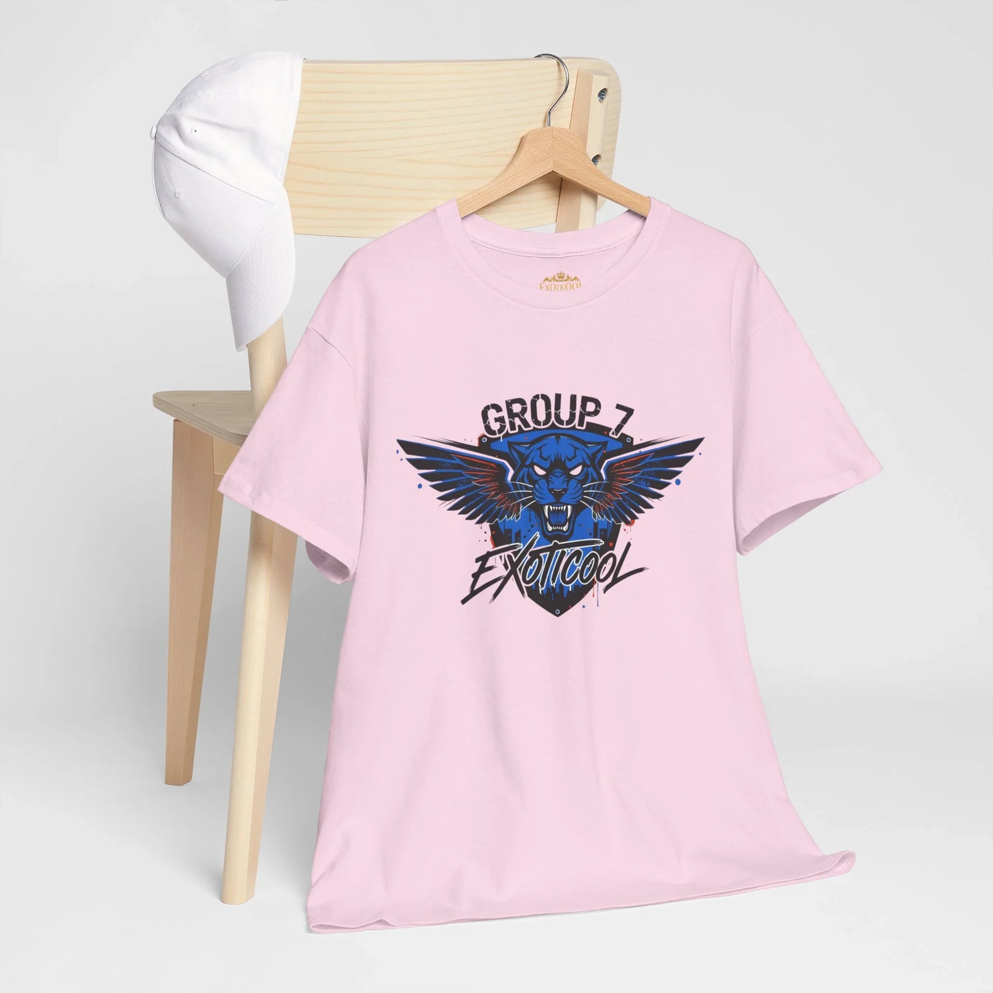 Pink Group 7 Exoticool t-shirt with blue panther graphic on hanger, white hat on wooden chair