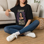 Seated model wearing the Classy Boujee Batsh*t black Halloween graphic tee
