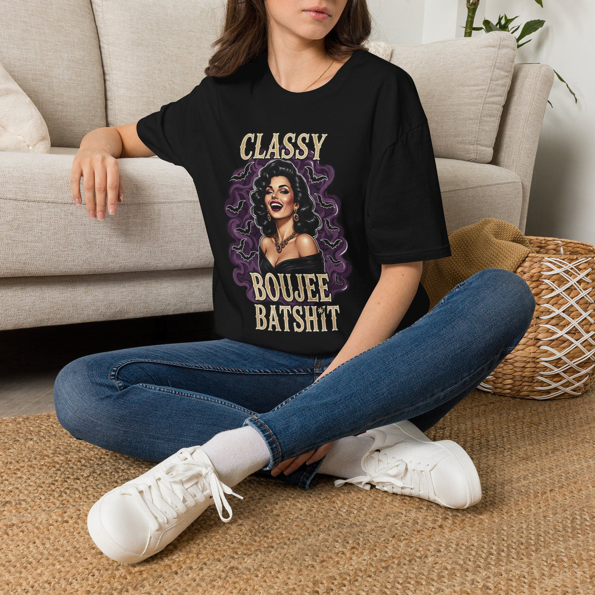 Seated model wearing the Classy Boujee Batsh*t black Halloween graphic tee