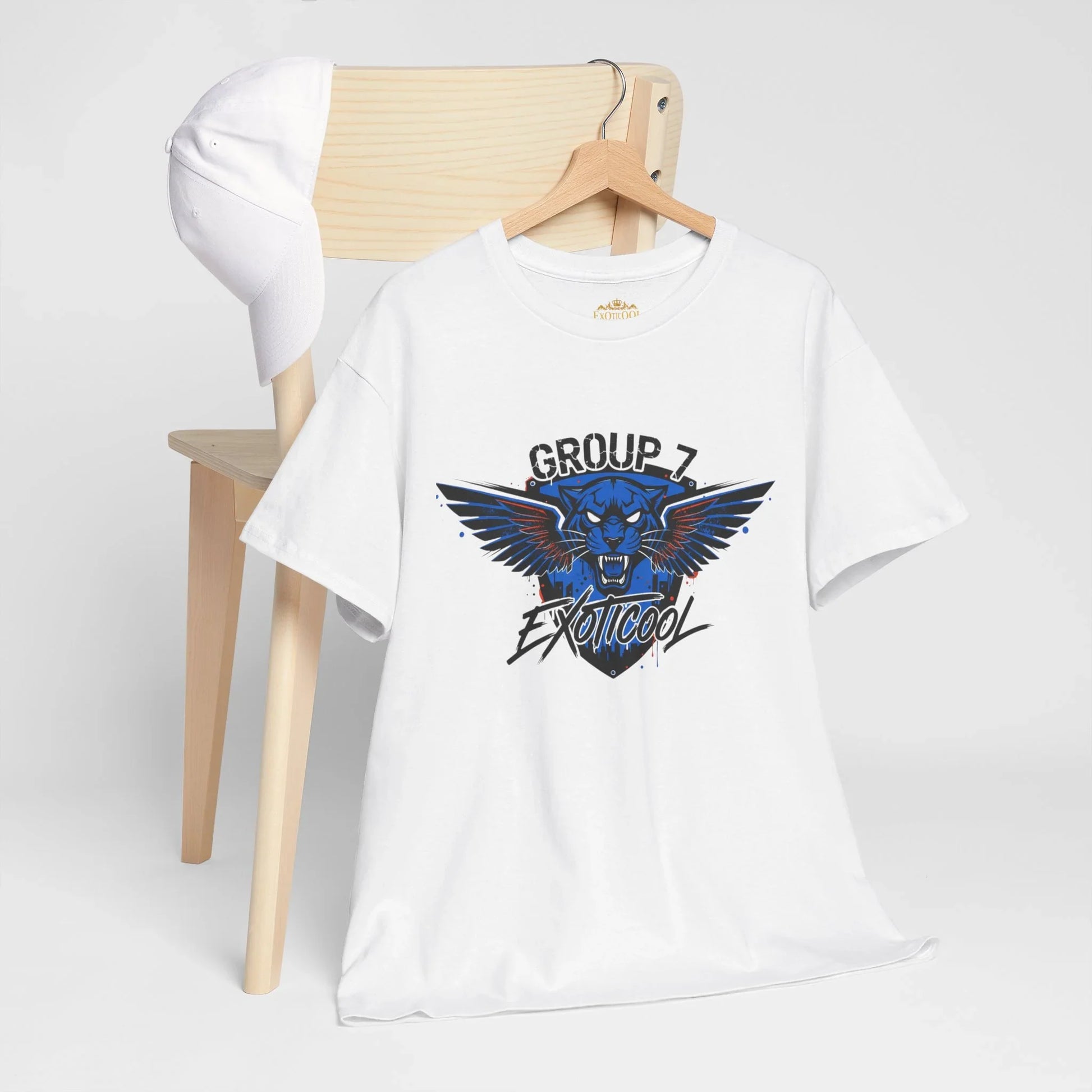 White t-shirt with blue panther graphic and 'Group 7 Exoticoool' text, on chair with cap