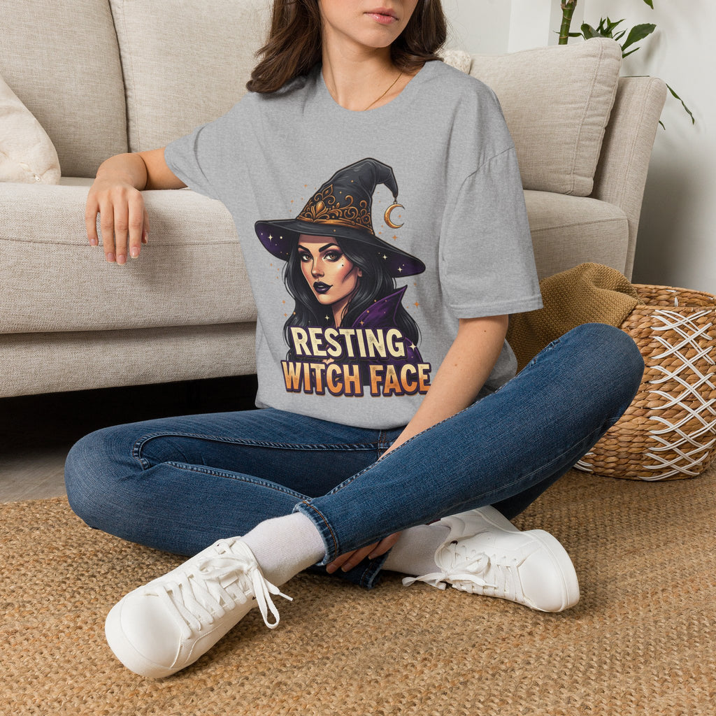 Seated model wearing the Resting Witch Face Halloween graphic tee in sport gray