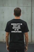 Back view of male model wearing black Exoticool Equality for Everyone T-shirt with “Equality Is Not an Opinion, It’s Evolution” statement in an urban setting