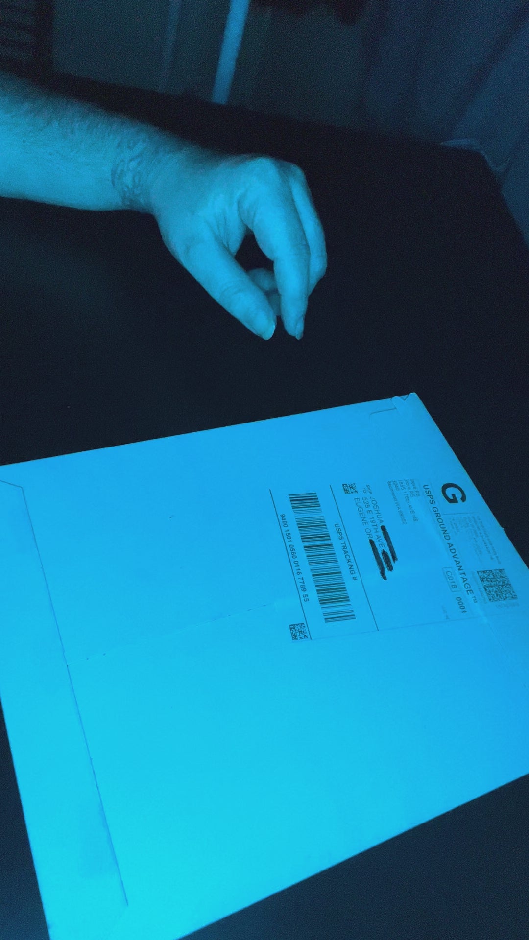 Video showing the bumper sticker package and unboxing under cyan lighting
