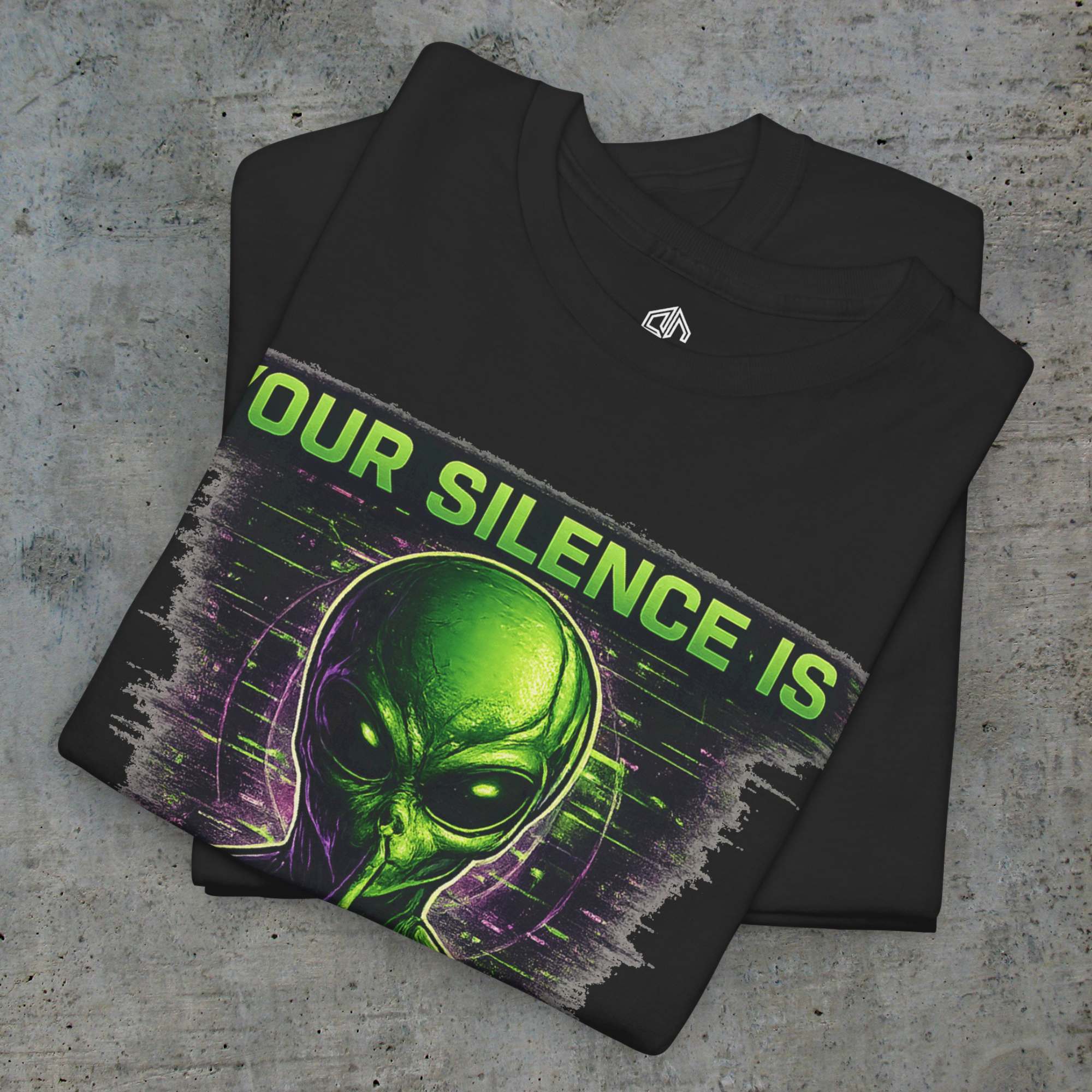 Folded black Your Silence Is Complicity tee showing the alien artwork and Exoticool neck label